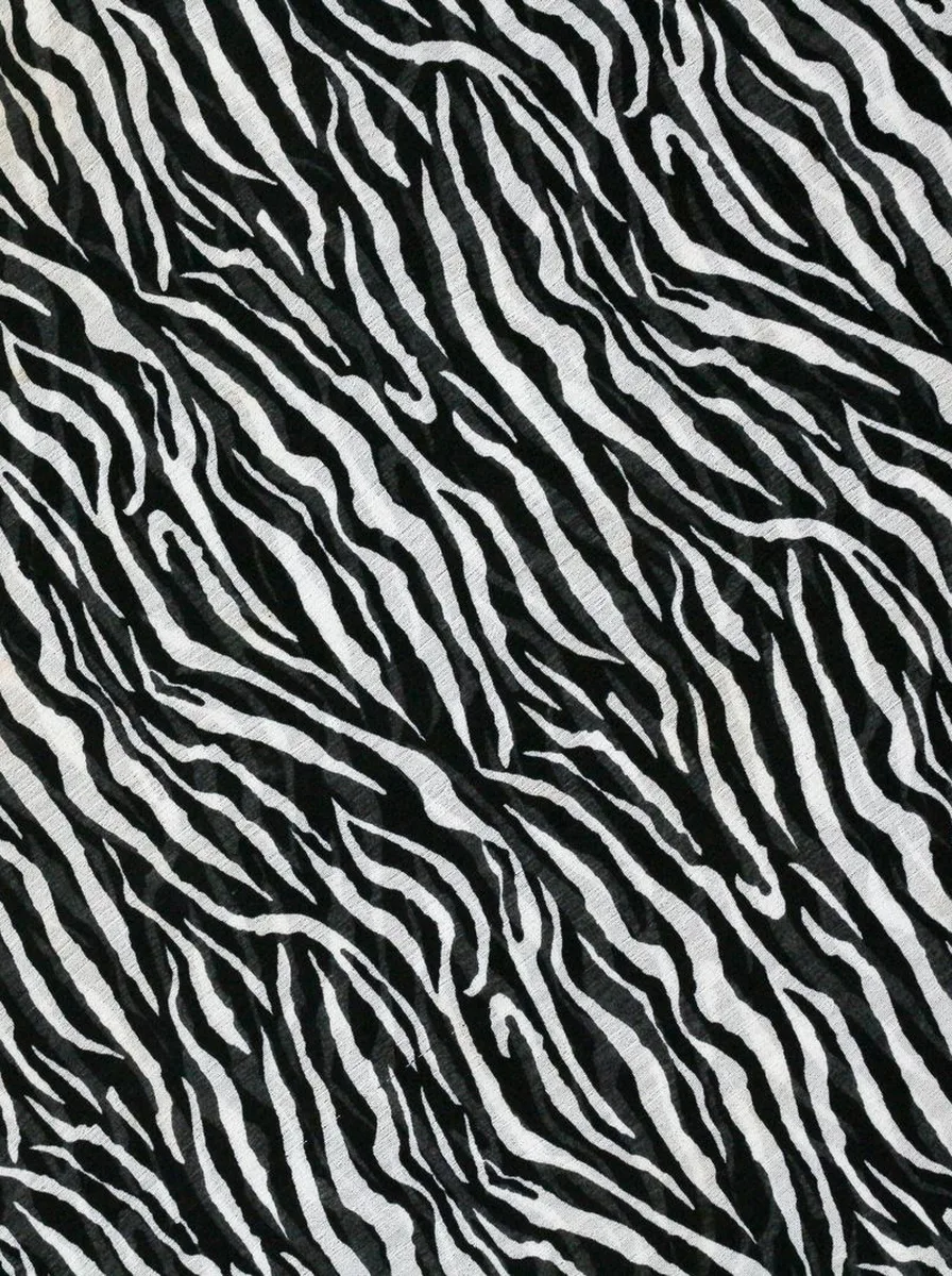 Sofa styled against bold animal print accent wall