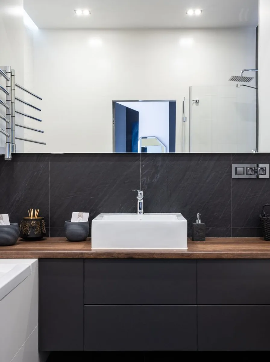 Modern bathroom detail with stone tray, concrete planter, and glass dispensers