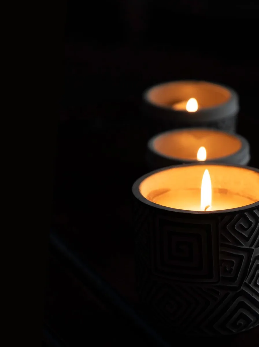 Black candle holders styled with wooden bowls on open living room shelves