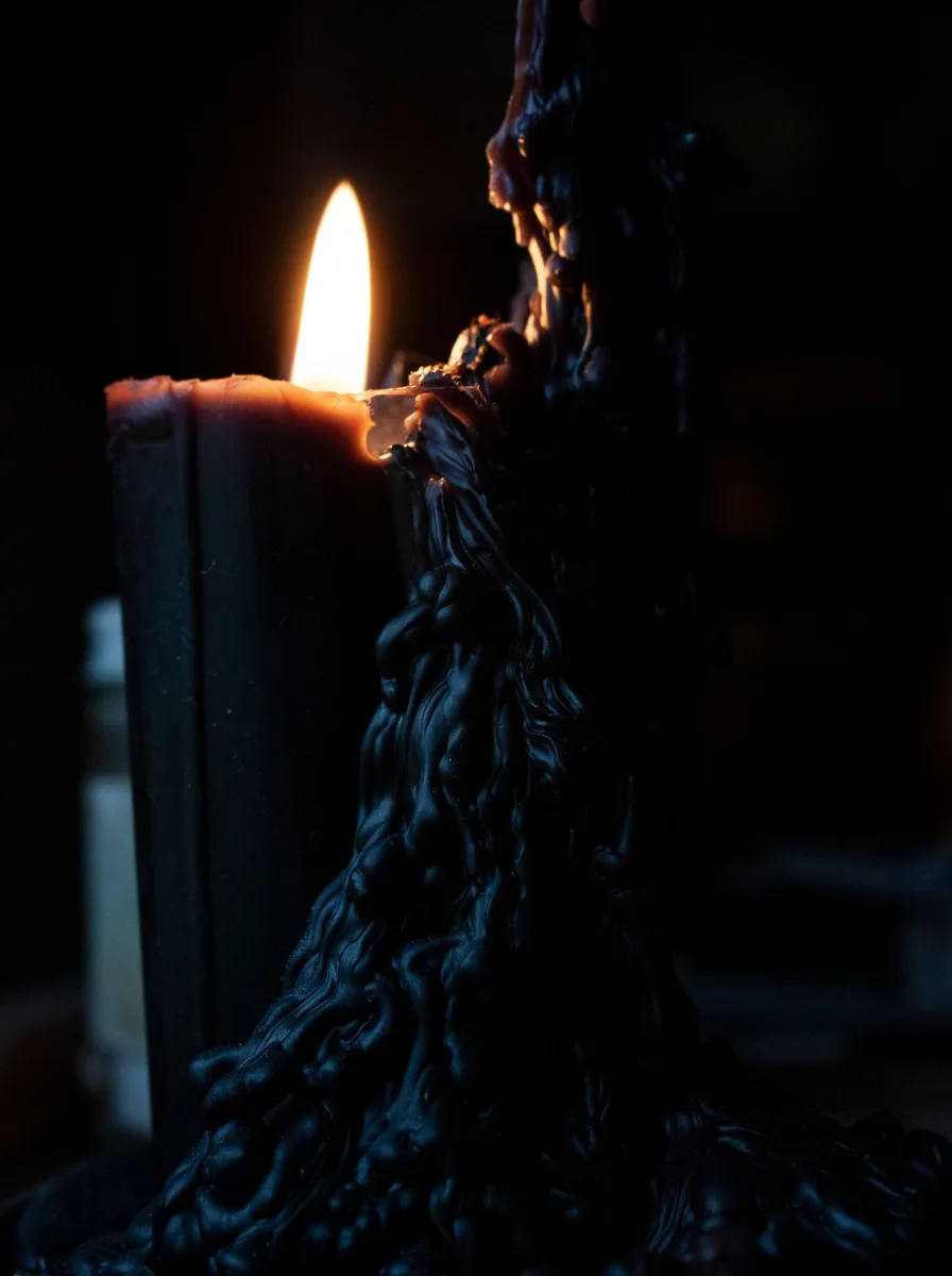 Oversized black floor lantern with a large candle in a bright entryway