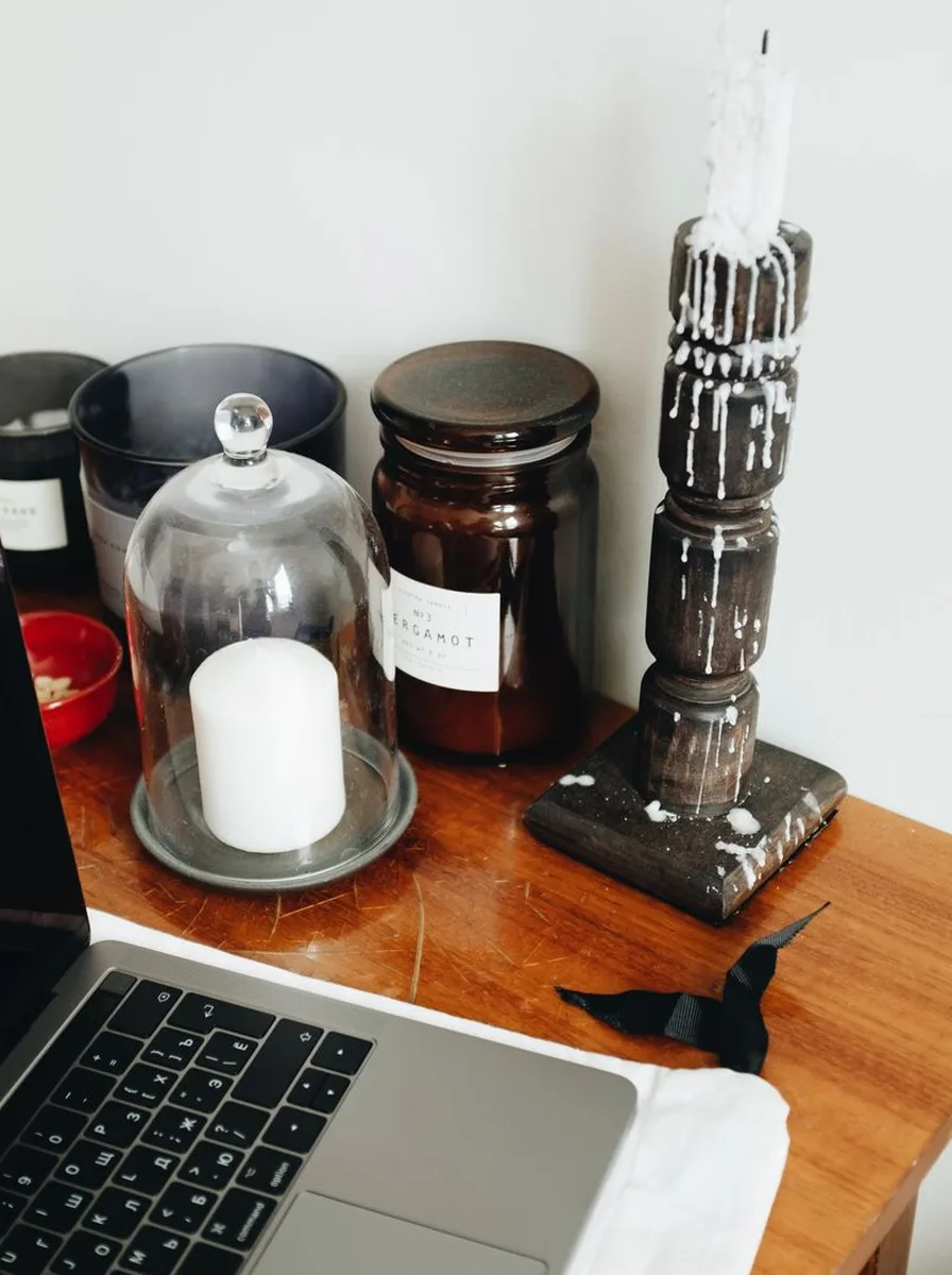 Small black tealight holders scattered among place settings on a dining table