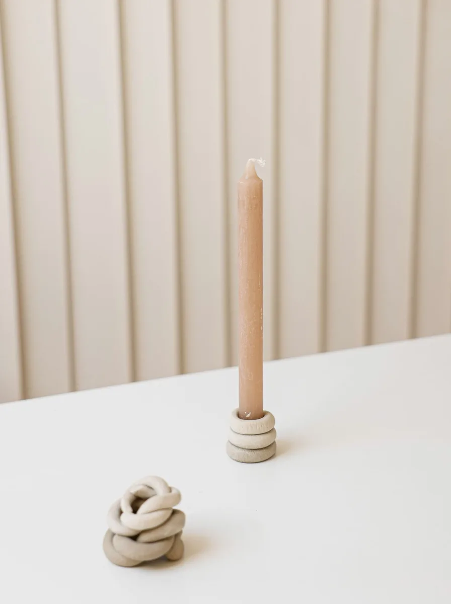 Matte black votive holders in a row on a modern dining table with minimal place settings