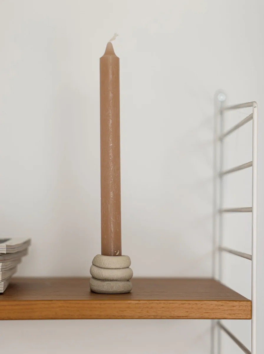 Black and glass candle holder with a lit candle on a home office desk