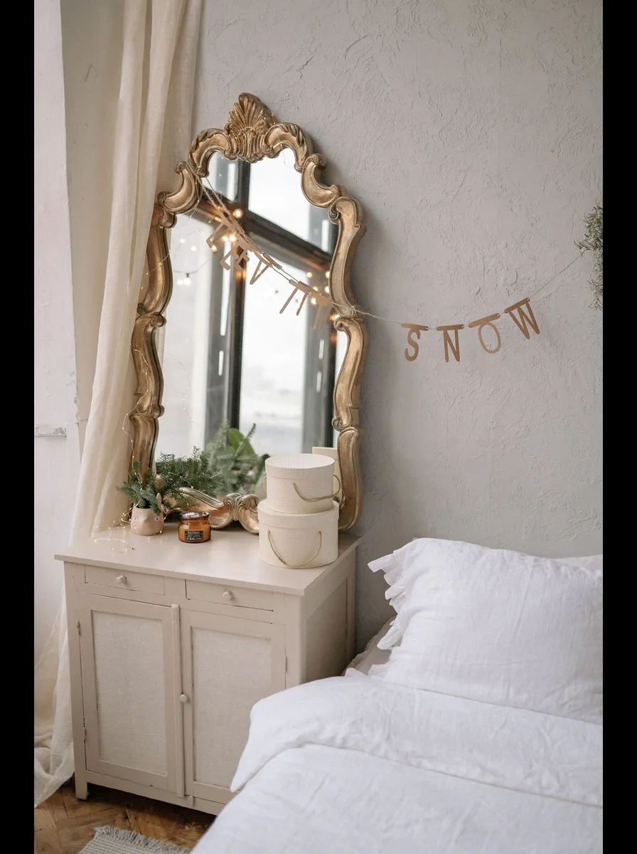 Bright minimal white bedroom with snow garland and mirror
