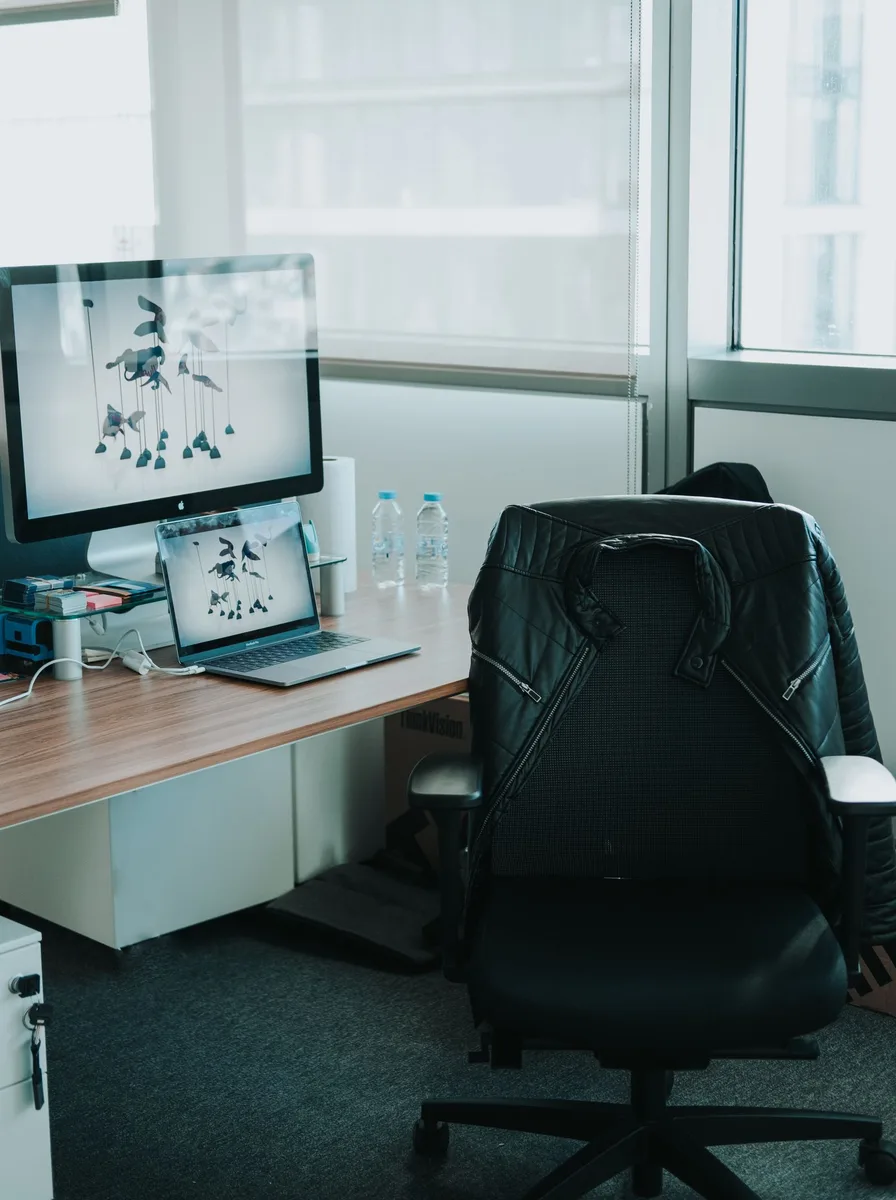 Black office chair at a dark wood desk