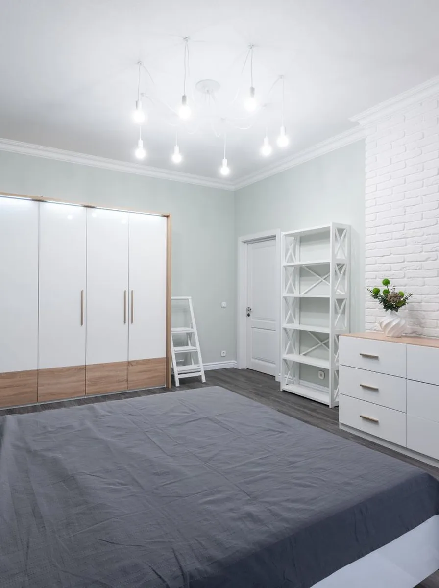 Bedroom with white fitted wardrobes and simple blue bedding on a budget