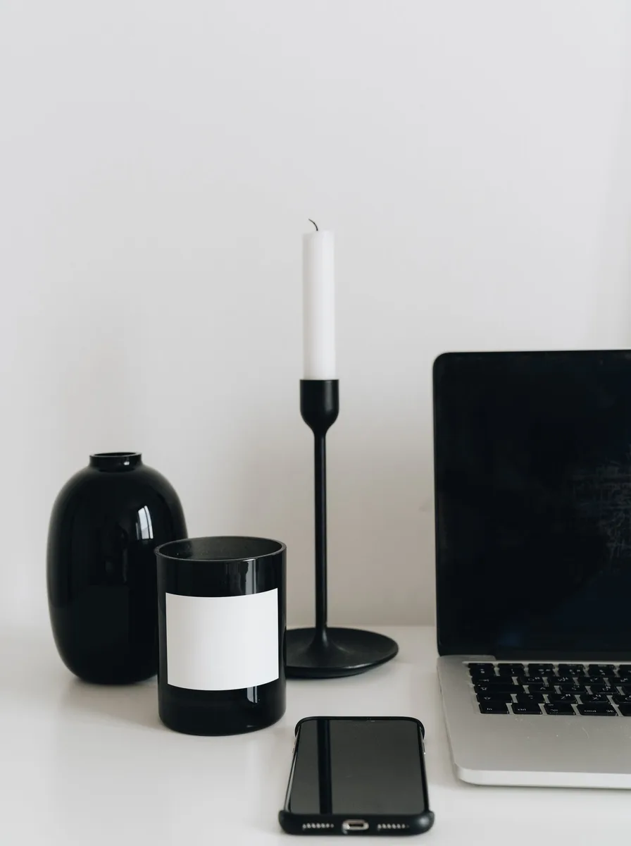 Matte black sculptural taper candle holders in twisted organic shapes on a wooden table