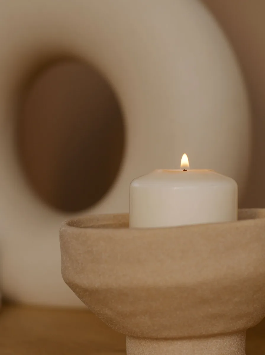 Cluster of small geometric brass candle holders of different heights on a coffee table