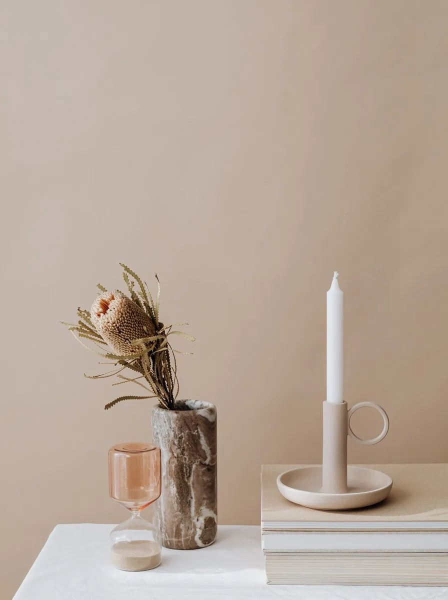 Large ceramic bowl candle with multiple wicks lit on a living room coffee table