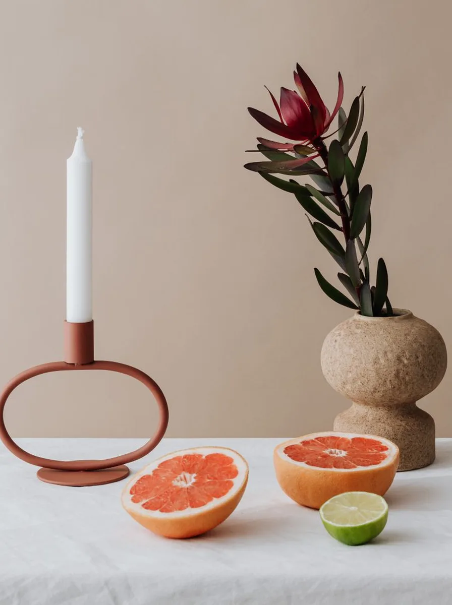 Textured gray stone candle holders with lit candles on a modern dining table runner
