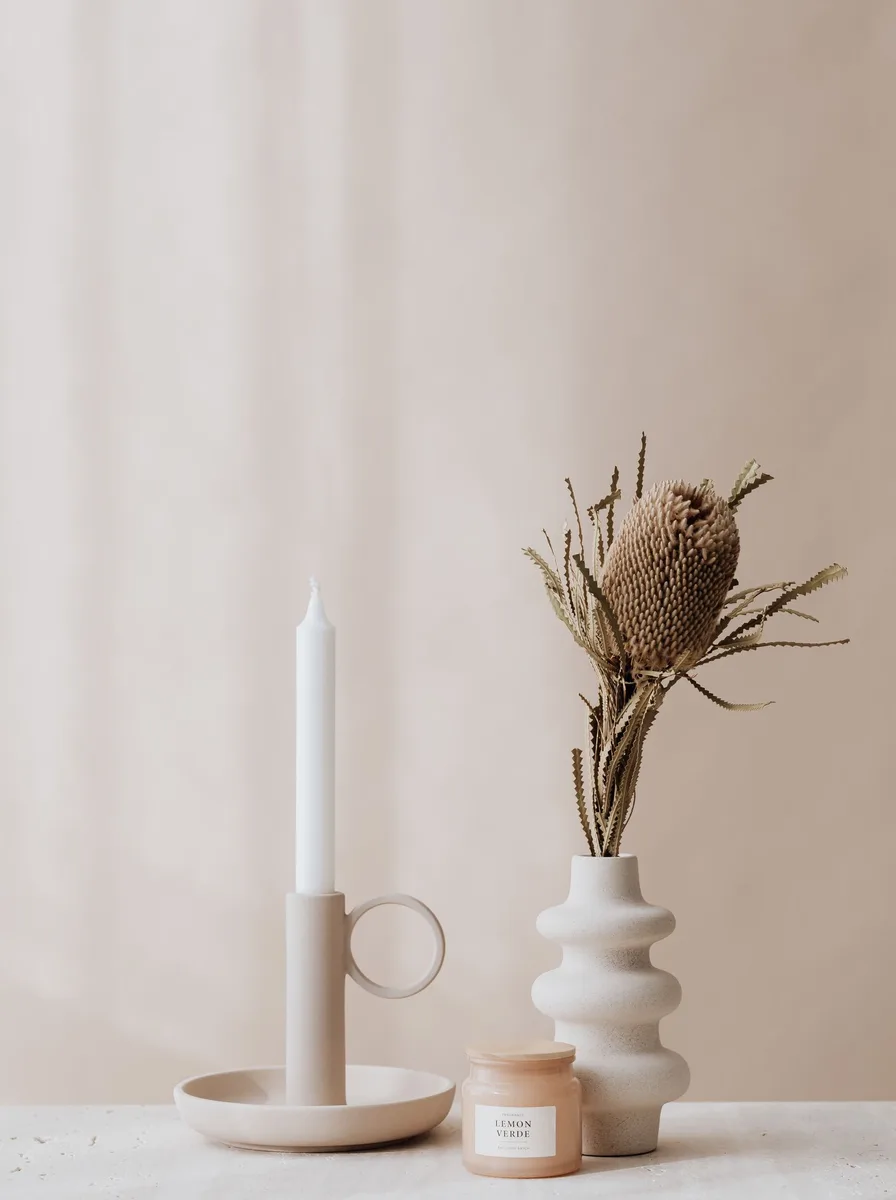 Asymmetric polished silver candle holders of varied heights on an entryway console table
