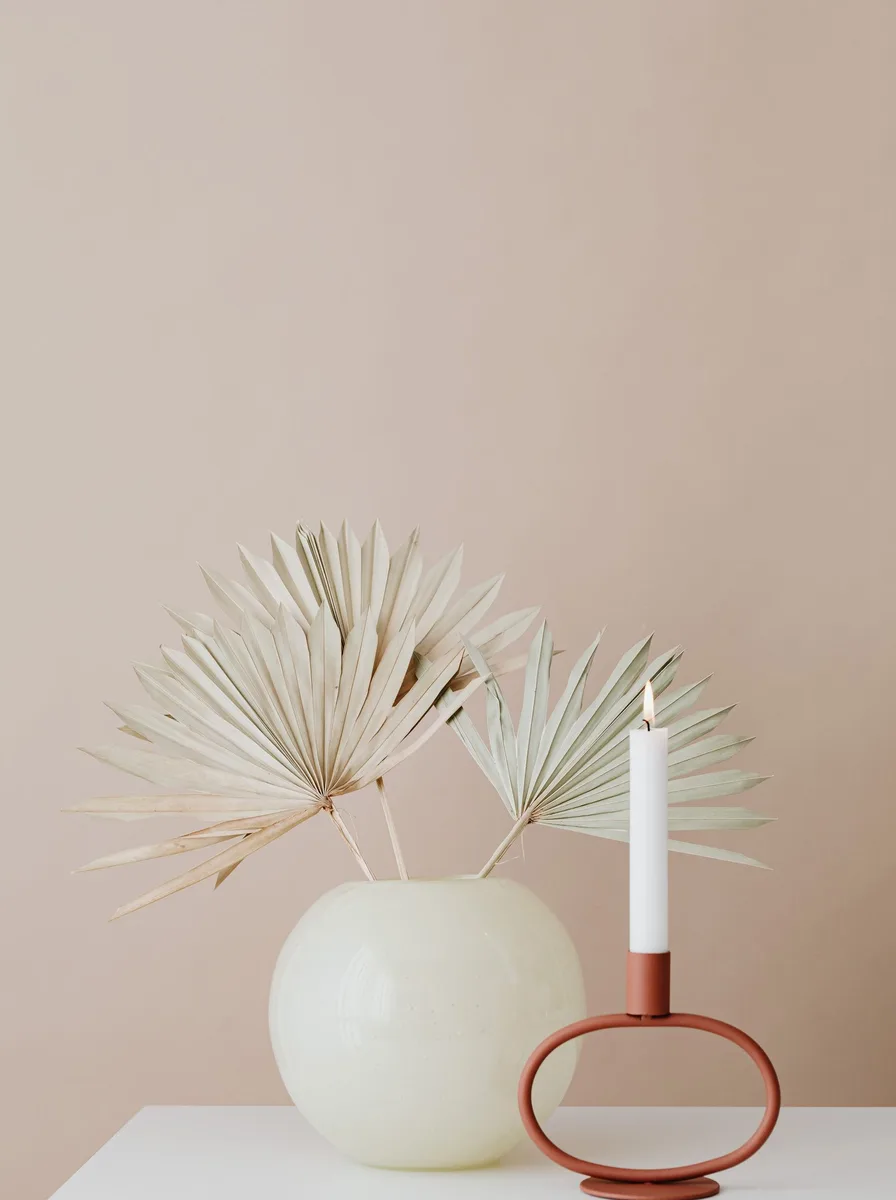 Tiered matte white modern candelabra with cream tapers on a dining sideboard