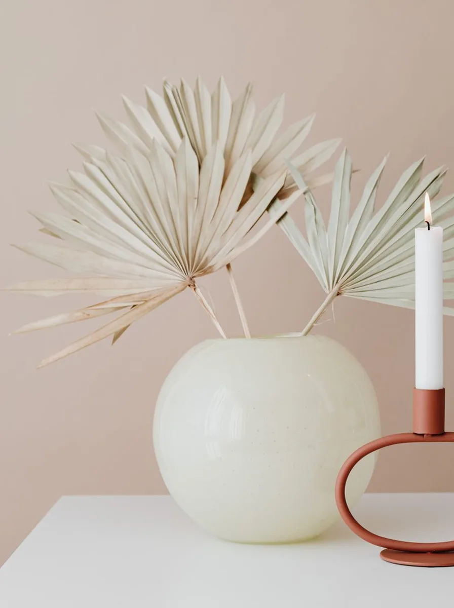 Round glass tea light spheres on gunmetal bases glowing on a living room shelf
