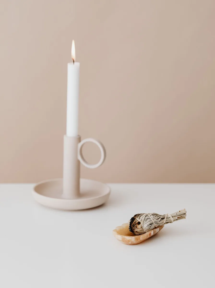 Monochrome black and white pillar candle holders in an entryway on a narrow console