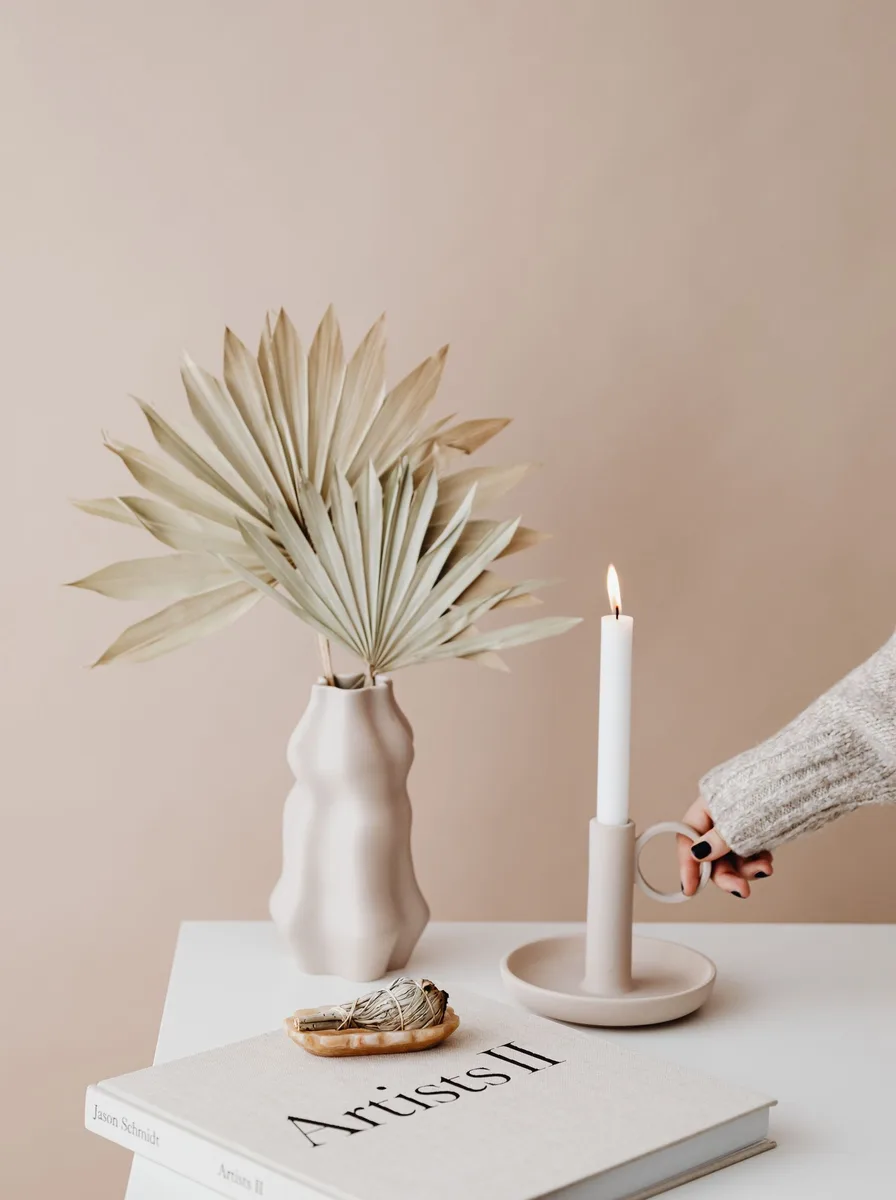 Row of modern candle holders in mixed finishes forming a centerpiece on a dining table