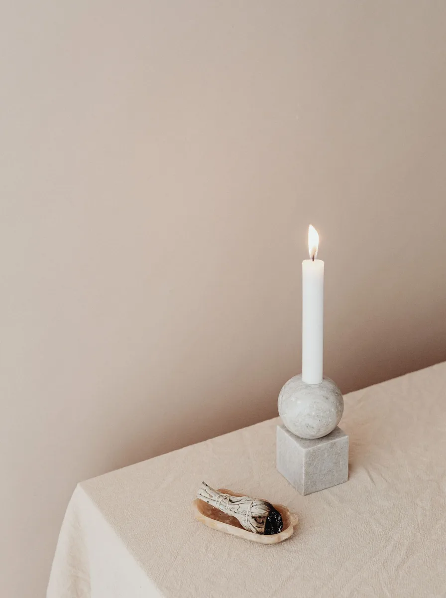 Black and gold candle holder pair glowing on a windowsill at evening