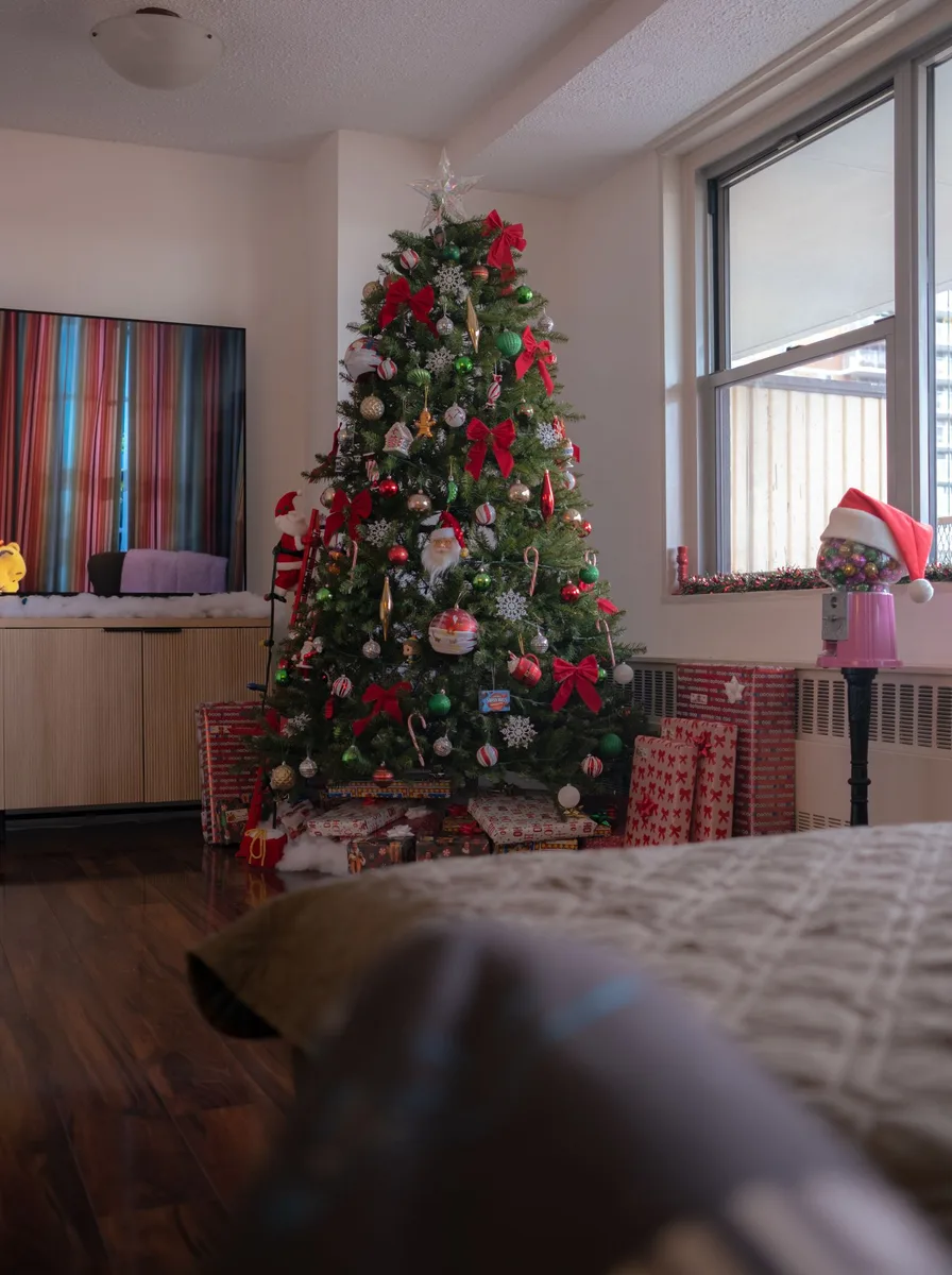 Christmas tree with gifts in a bedroom corner