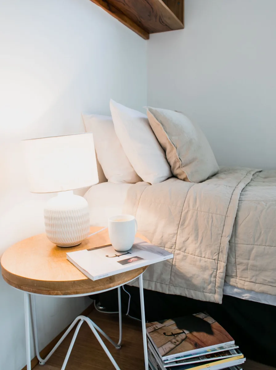 Cozy bedroom reading corner with warm lamplight