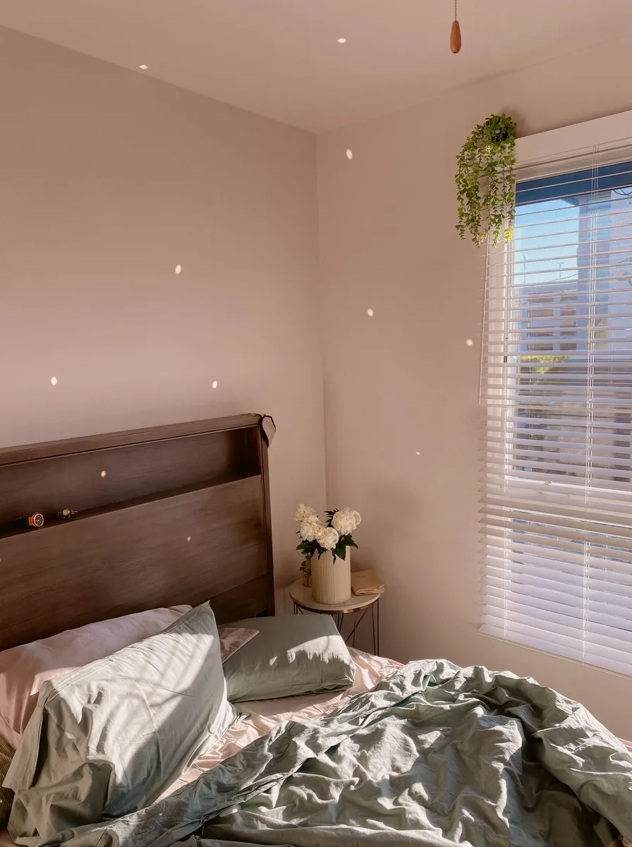 Cozy bedroom corner with twinkling string lights and soft grey bedding