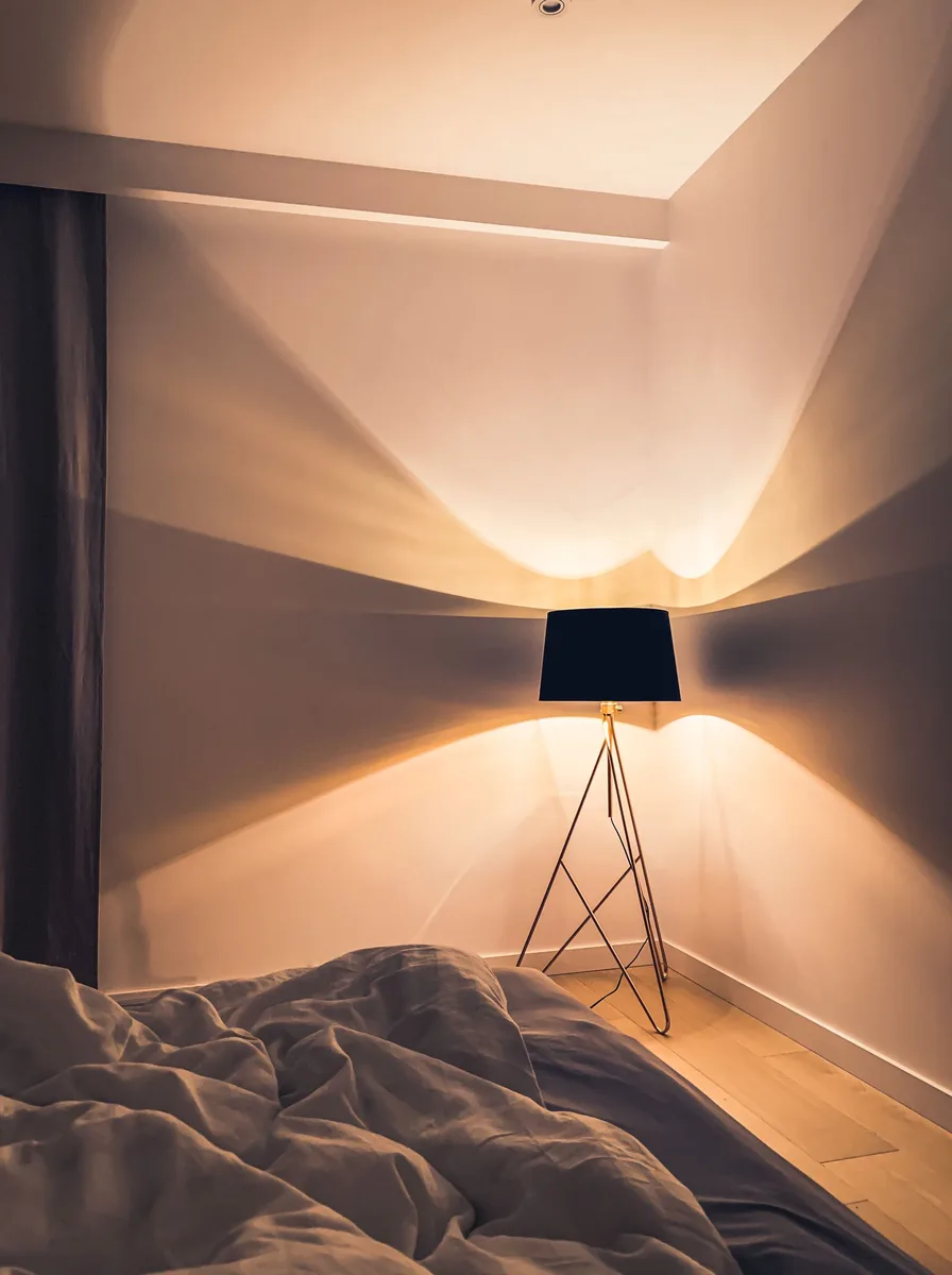Dark bedroom with tripod floor lamp