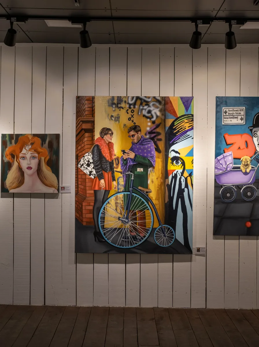 Colourful pop-art canvases on a panelled wall under track lighting