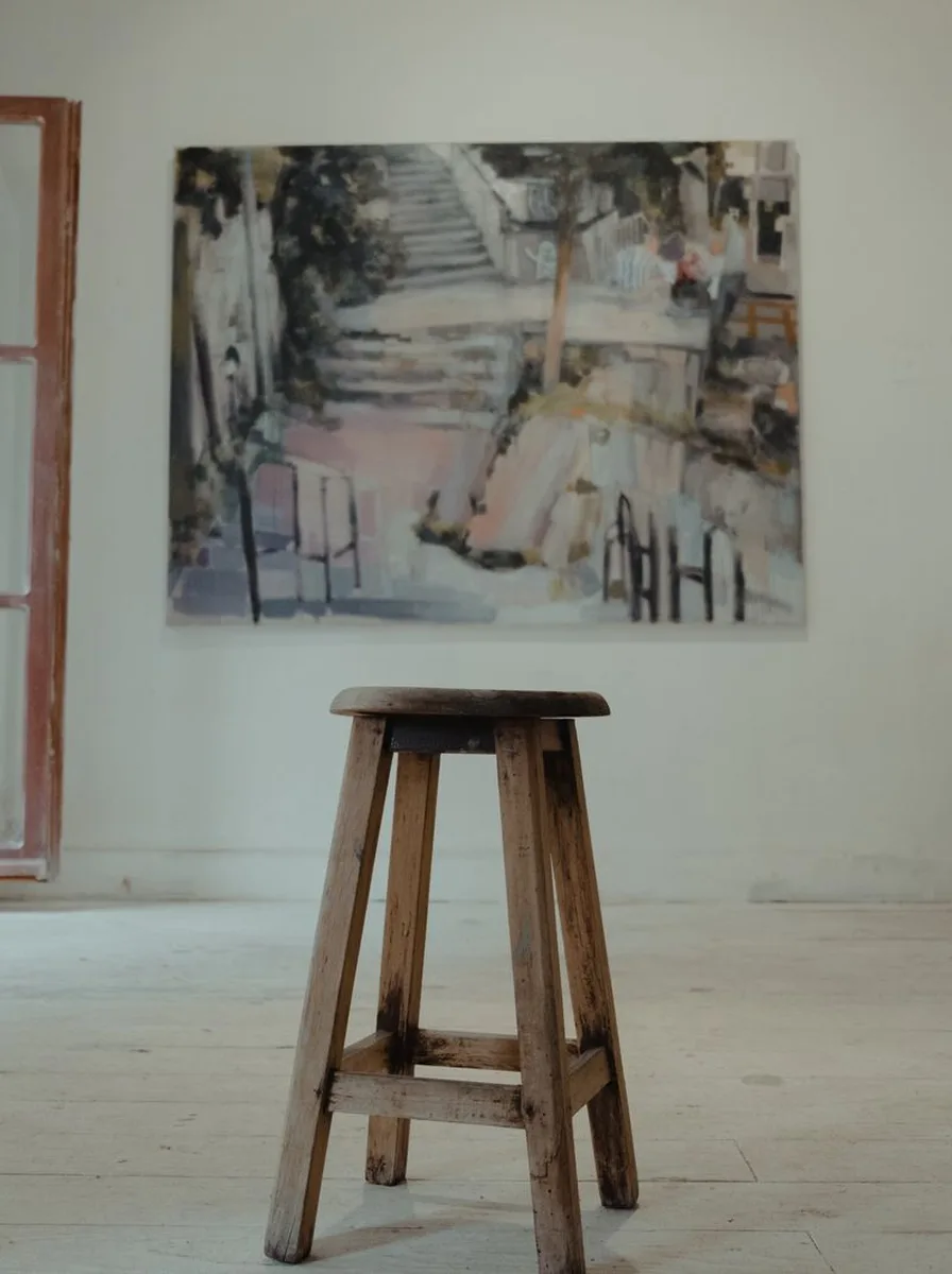 Vintage travel poster canvas of a staircase hanging above a wooden stool