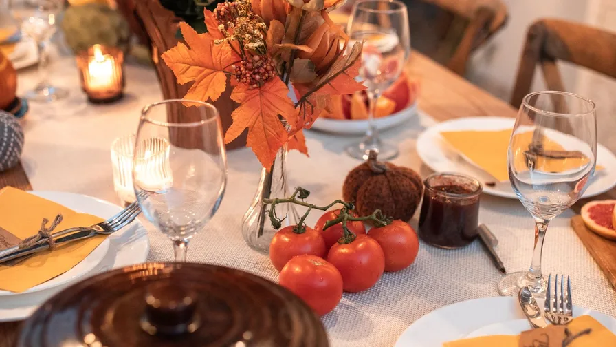 Cozy farmhouse dinner table decor with rustic wood and warm candlelight