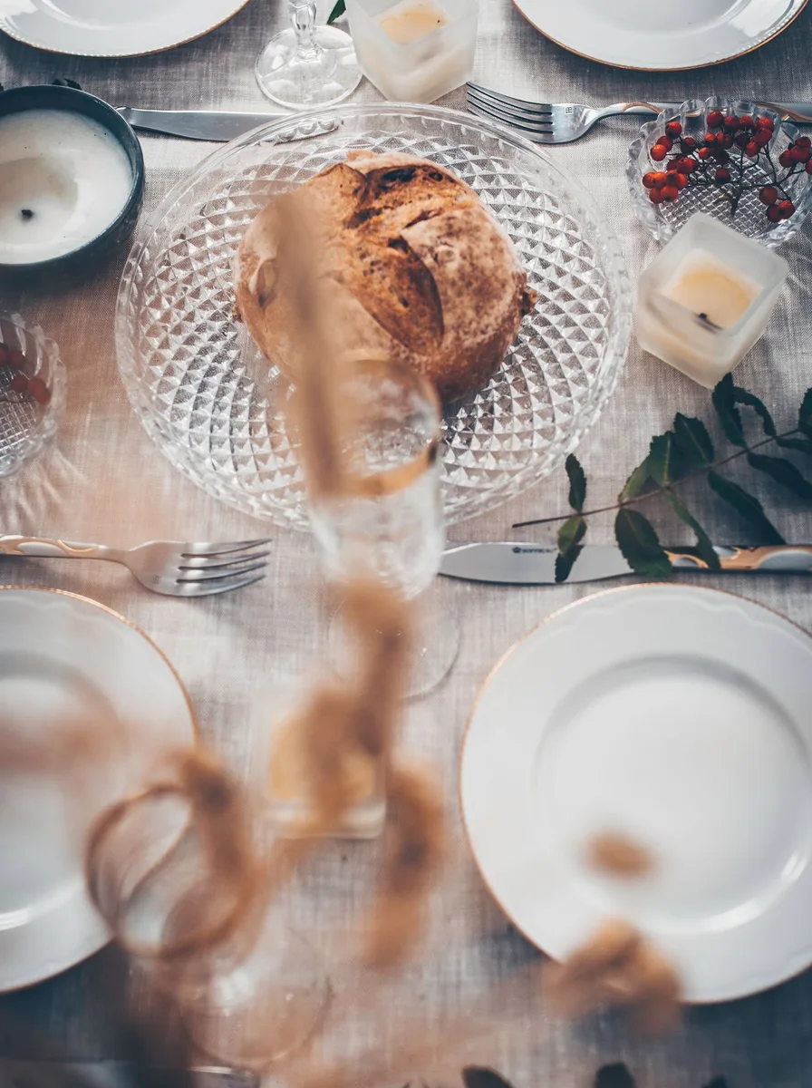 Small luxe details on a dinner table with herb sprig and ribbon-tied napkin
