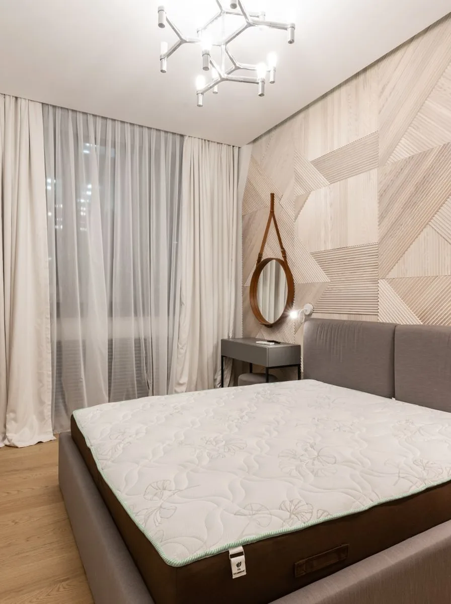 Bedroom with geometric wood panel feature wall and modern pendant light
