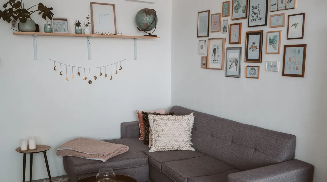 Curated gallery wall of framed art above a sofa in a bright living room