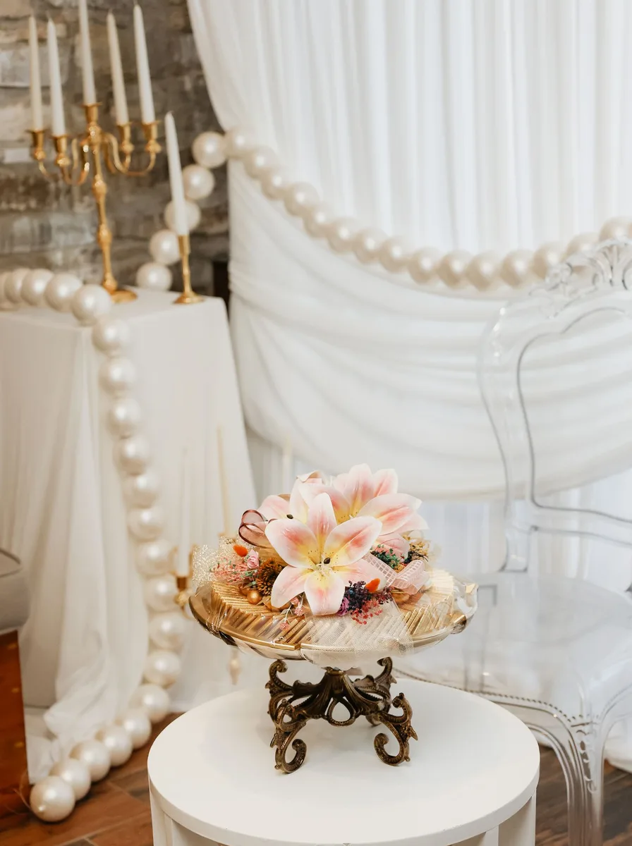 Vintage gilded three-arm candelabra with lit candles on a bedroom dresser
