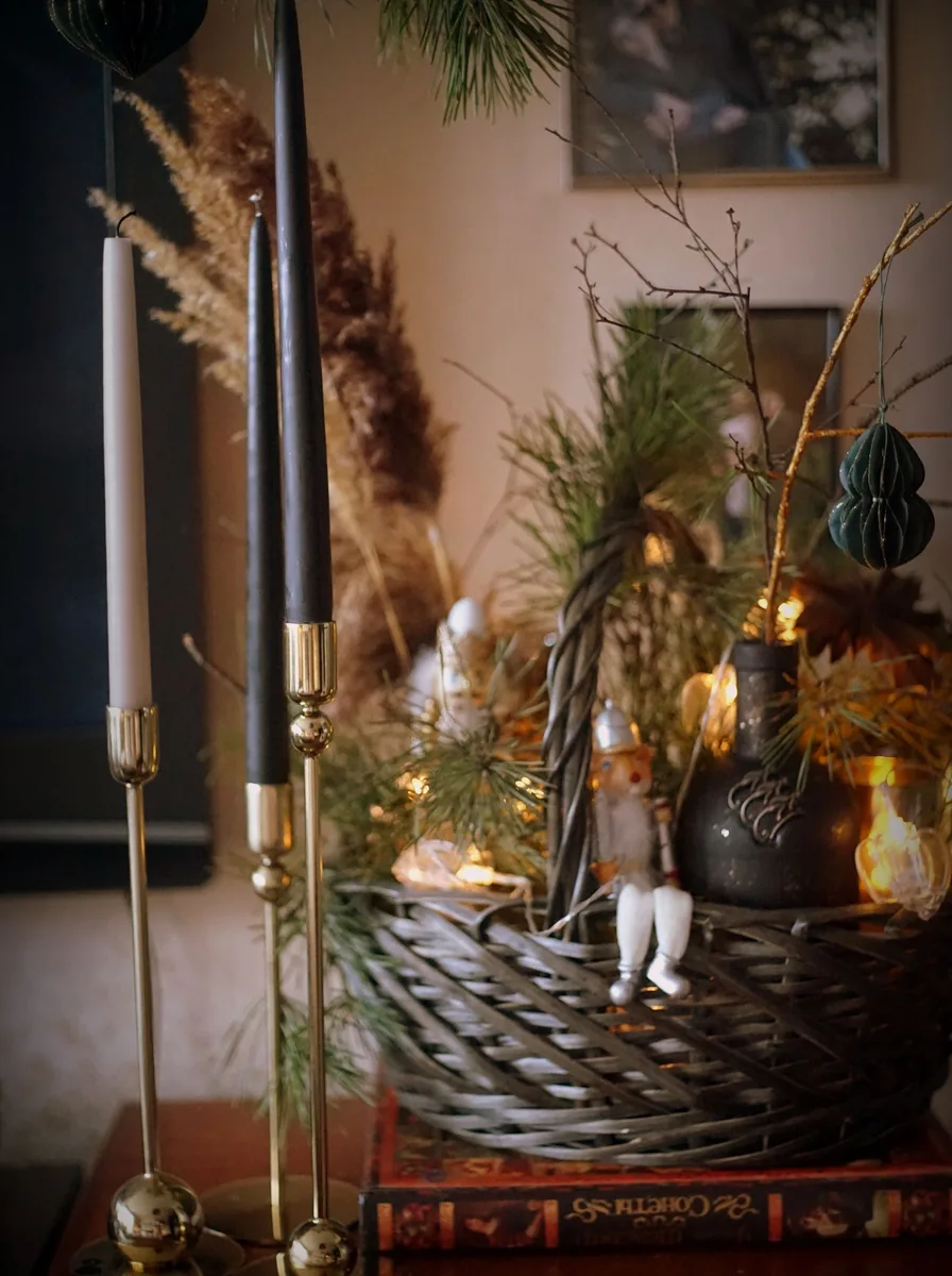 Long gold tray with pillar candles and greenery styled on a kitchen island