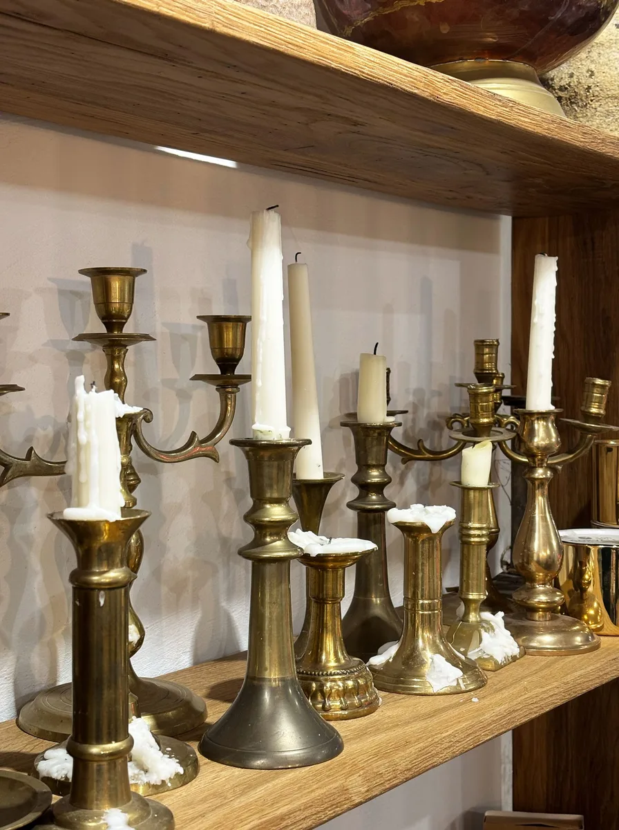Tall gold floor-standing candelabra with lit tapers in a living room corner