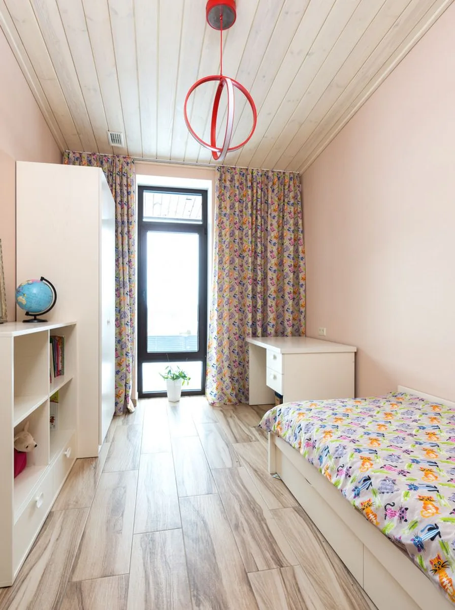 Toddler bed with sheer canopy and plush bedding in soft colours