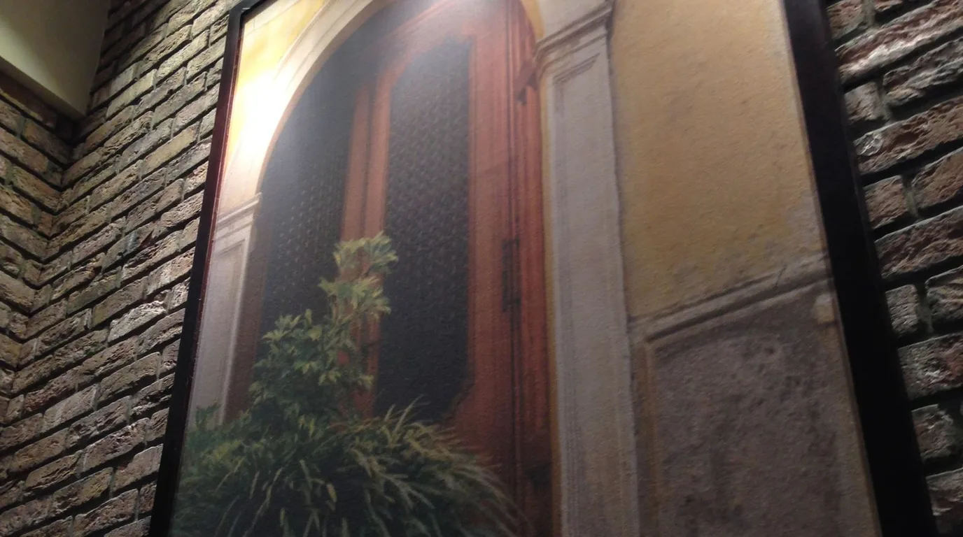 Arched doorway with a painting and a leafy plant