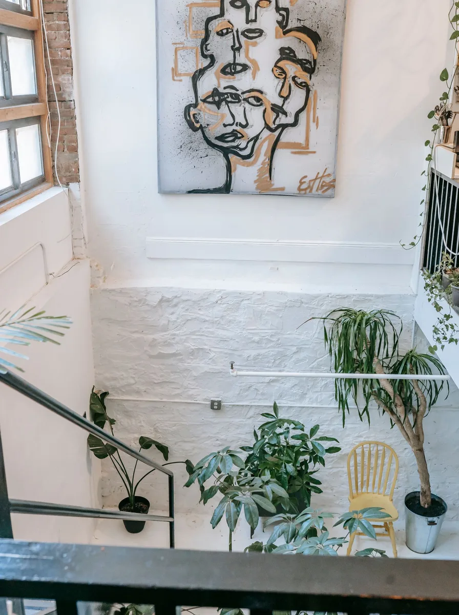 Large abstract face painting hung high on a stair wall