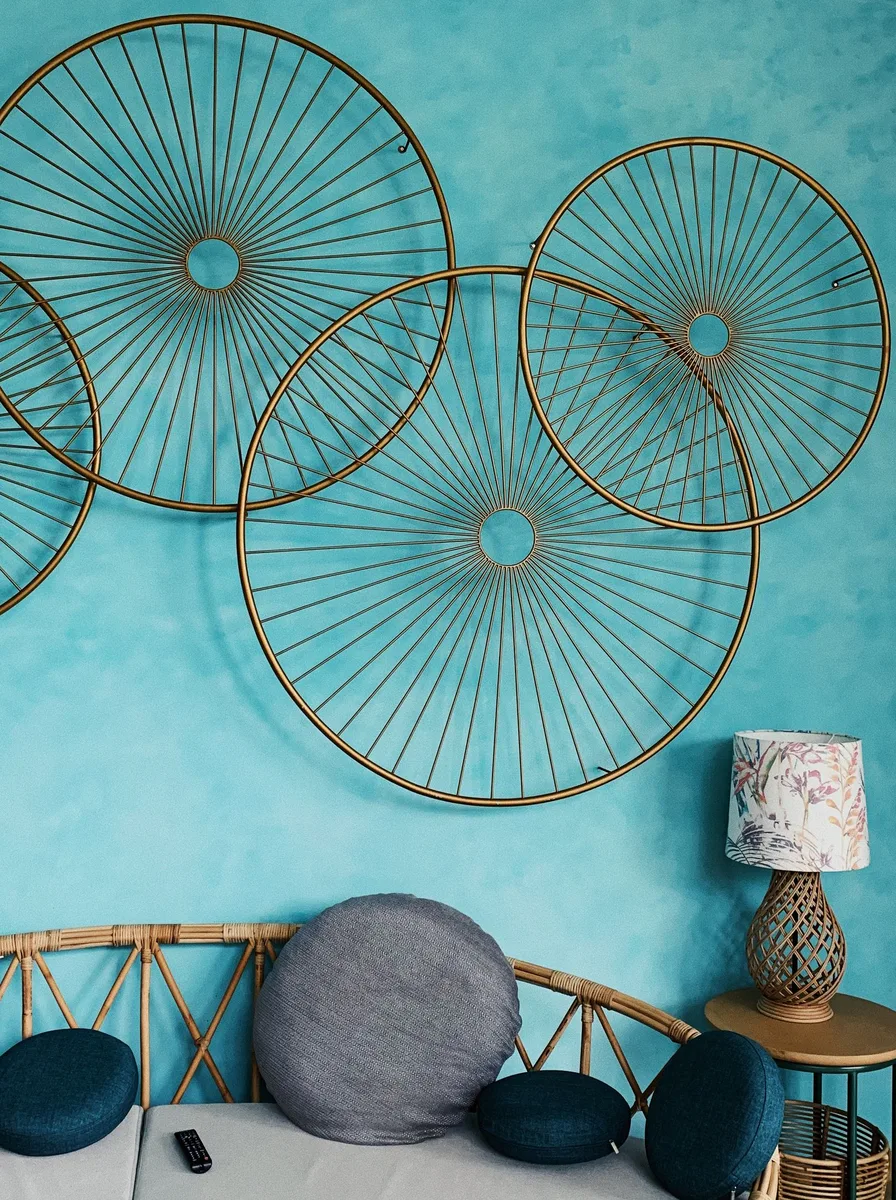 Oversized wire circle sculptures on a turquoise wall