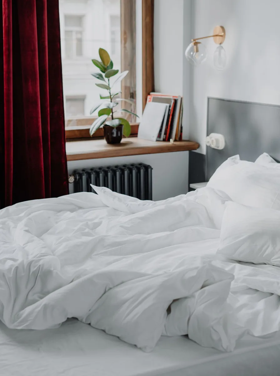 Bright bed with red curtains