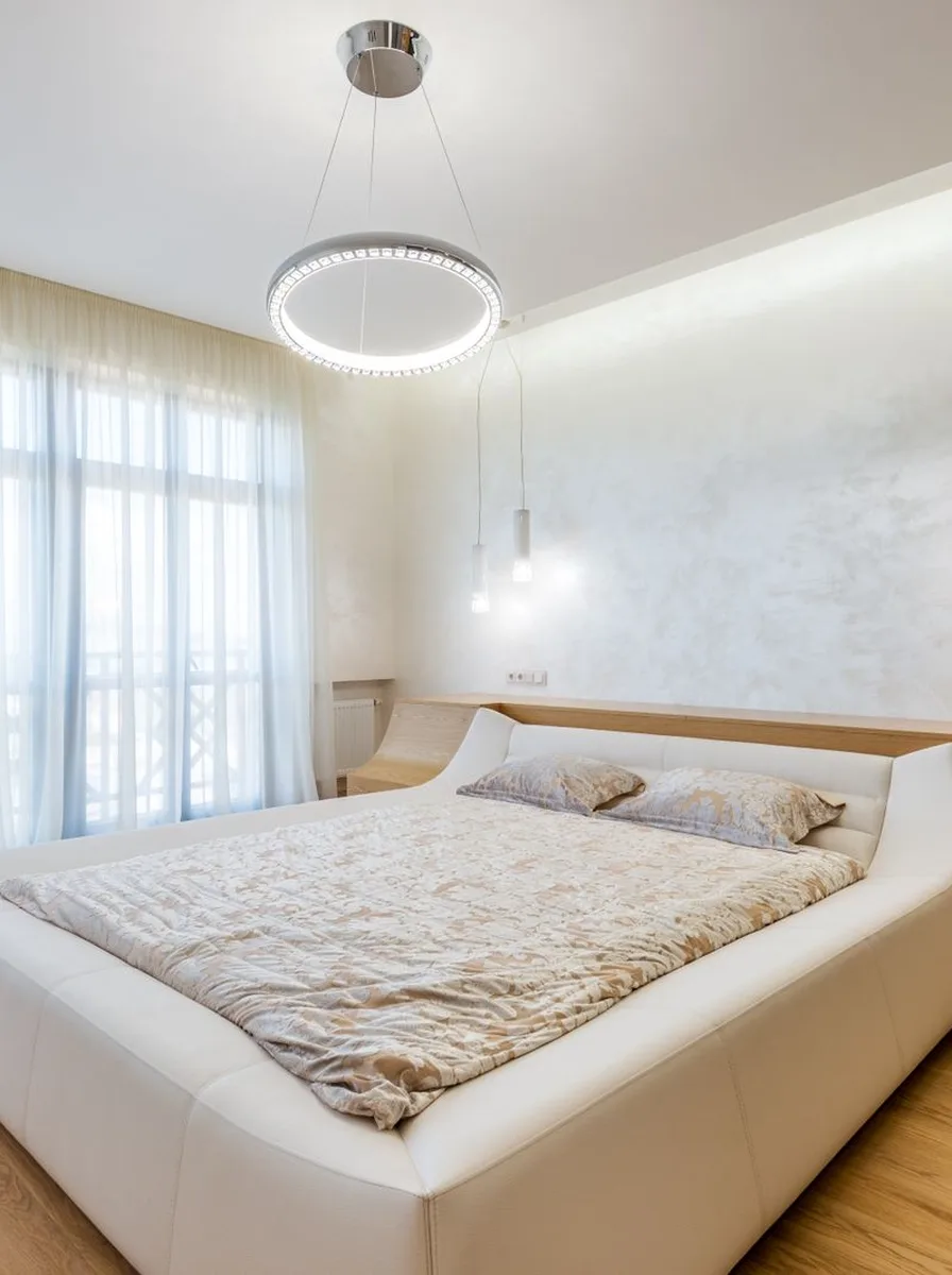 White bedroom with ring pendant light
