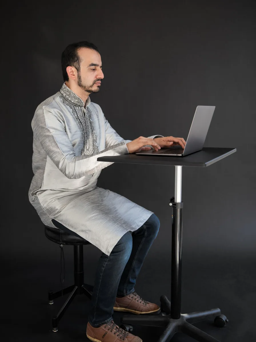 Adjustable drafting stool at a standing desk