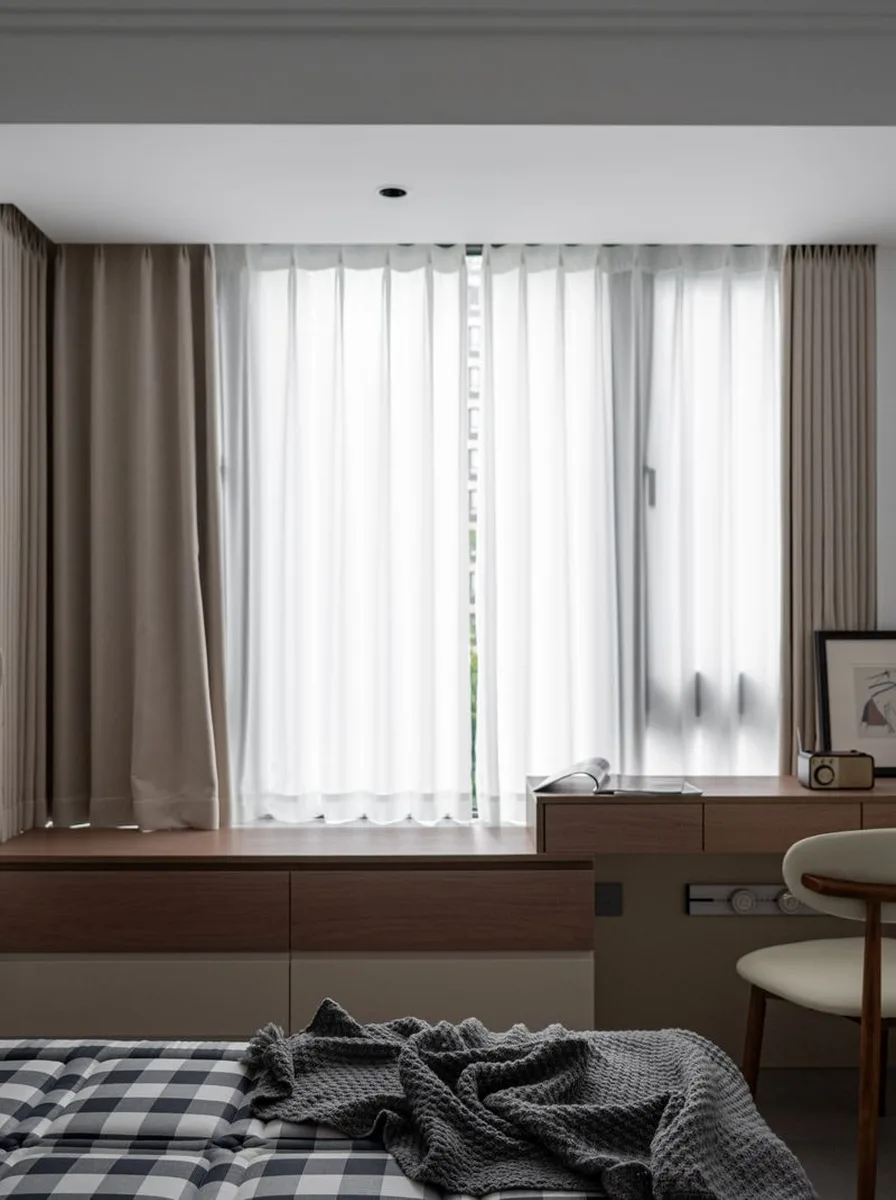 Calm white bedroom with sheer curtains and a simple wooden desk