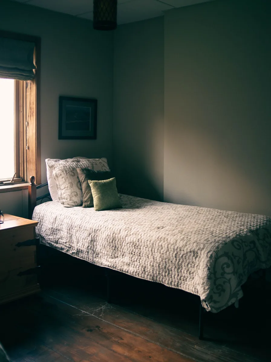 Simple daybed with white quilted bedding and cushions in a calm minimal bedroom