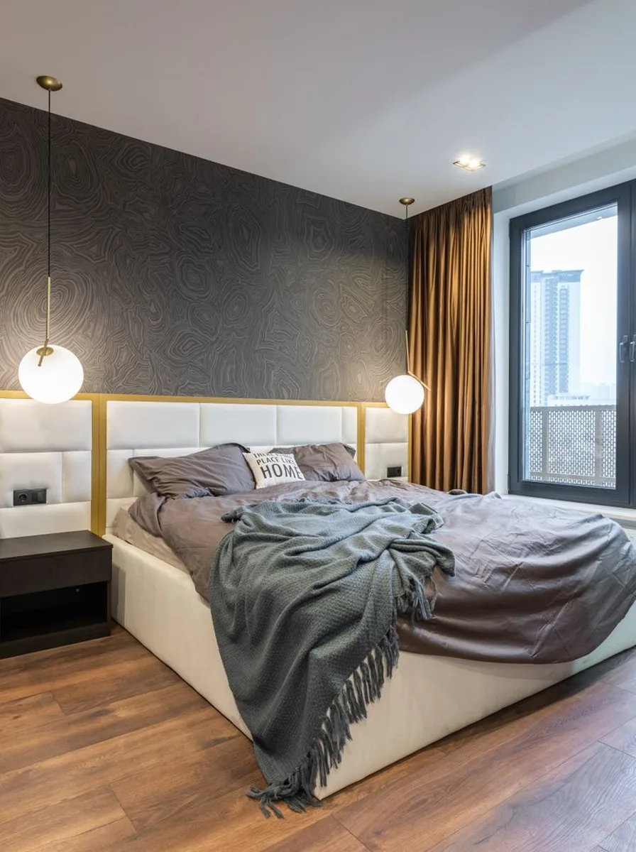 Modern bedroom with gold accent lighting and a sleek upholstered bed