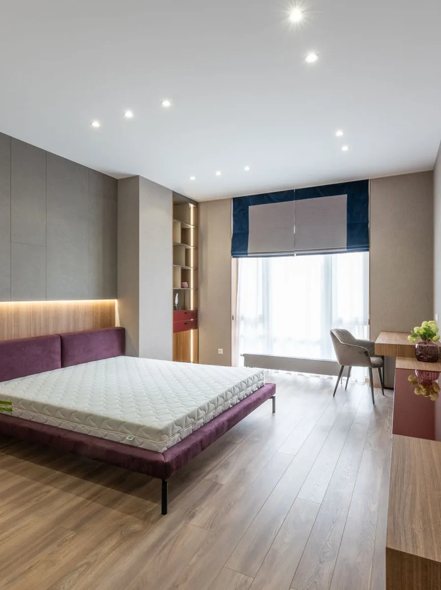Modern bedroom with purple accent wall and minimalist styling