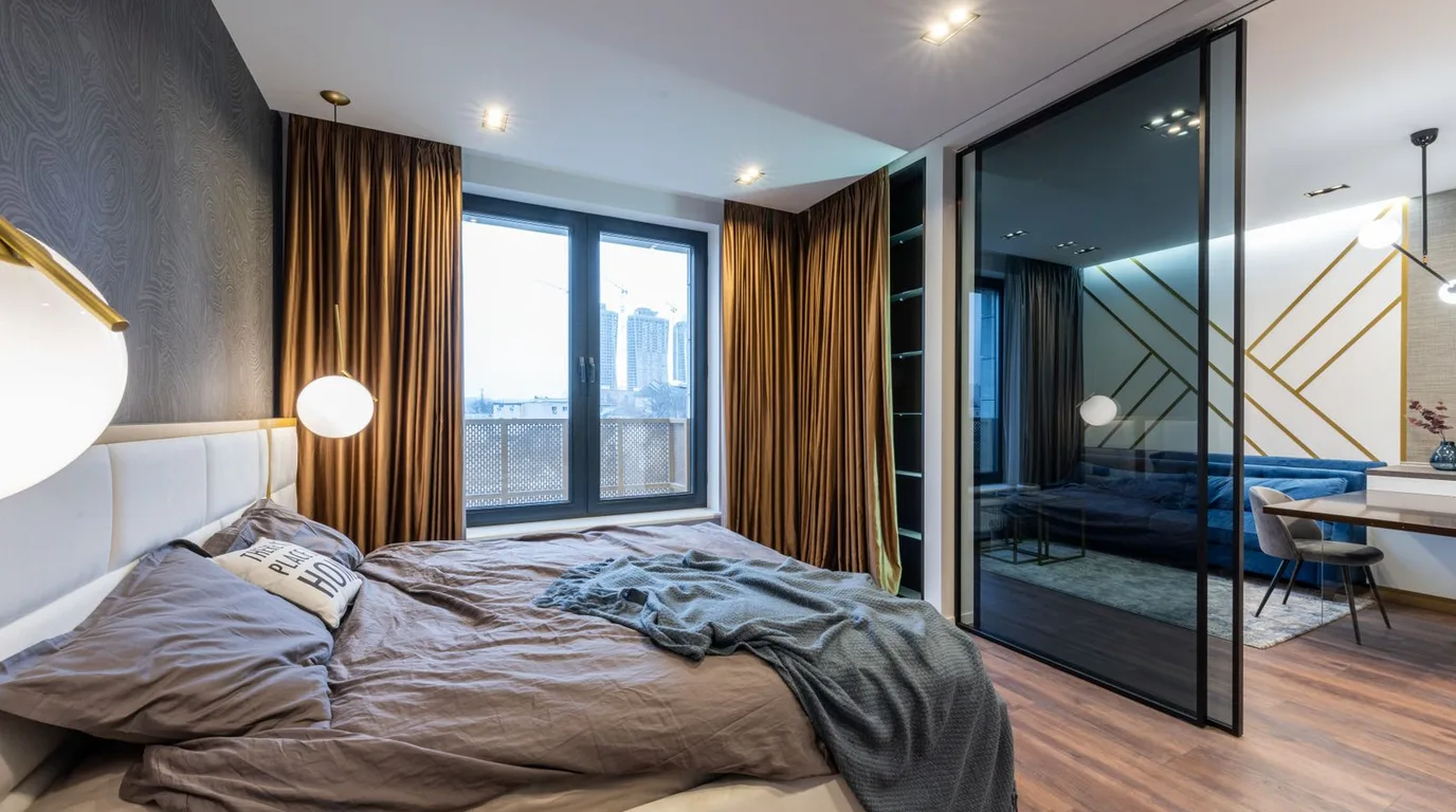 Luxurious modern bedroom with glass wardrobe wall and elegant lighting