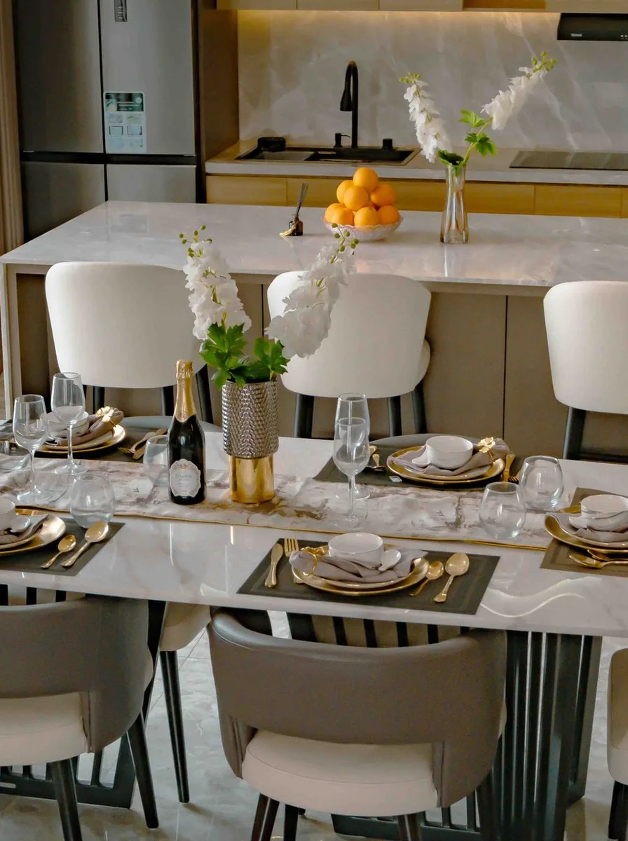 Bright dining area with a marble kitchen island styled with white orchids