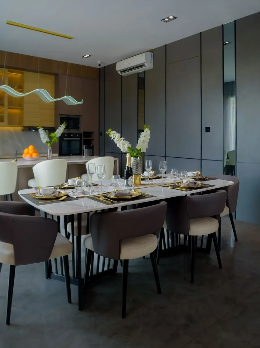 Dining room with dark grey panelled walls and bright yellow abstract art