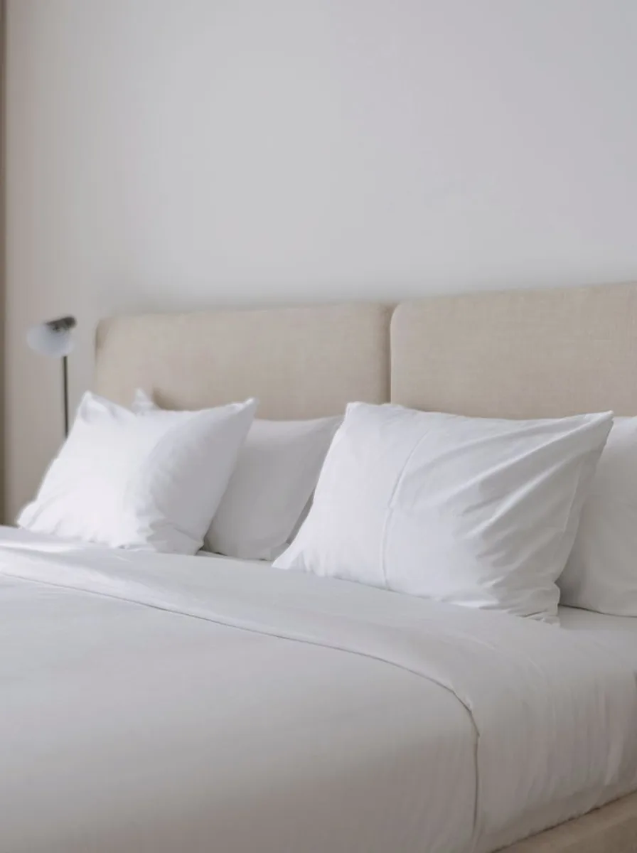 White bed with beige upholstered headboard