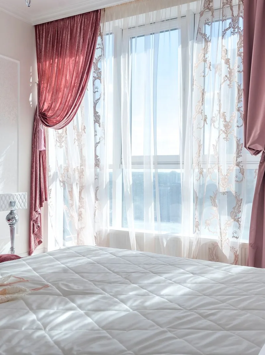 White bed with pink curtains