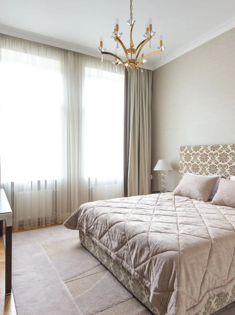 Beige quilted bedroom with chandelier